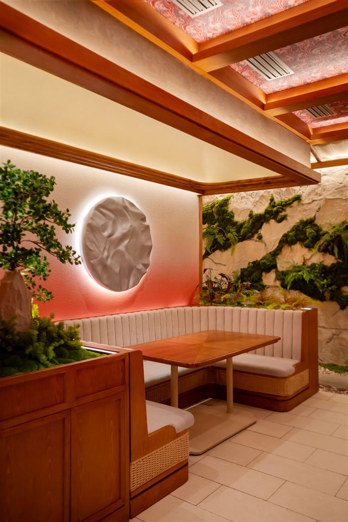 Banquette booth at Apollo Wu beneath a sculptural moon